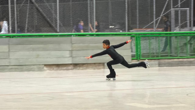 Joven patinador entrenando en pista