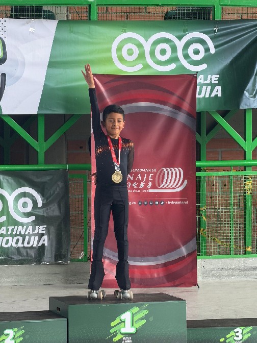 Deportista celebrando medalla de oro en patinaje