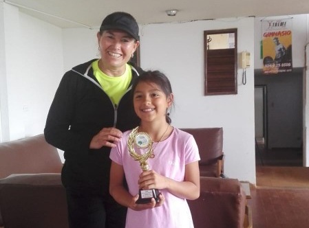 Niña deportista recibiendo trofeo por mérito académico